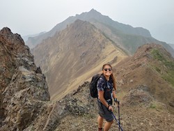 Image of Mei Qiu standing on a mountaintop. 